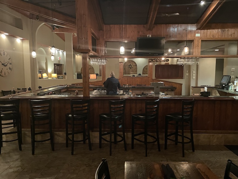 Bar area with wooden decor and seating inside Turner’s Kitchen + Bar