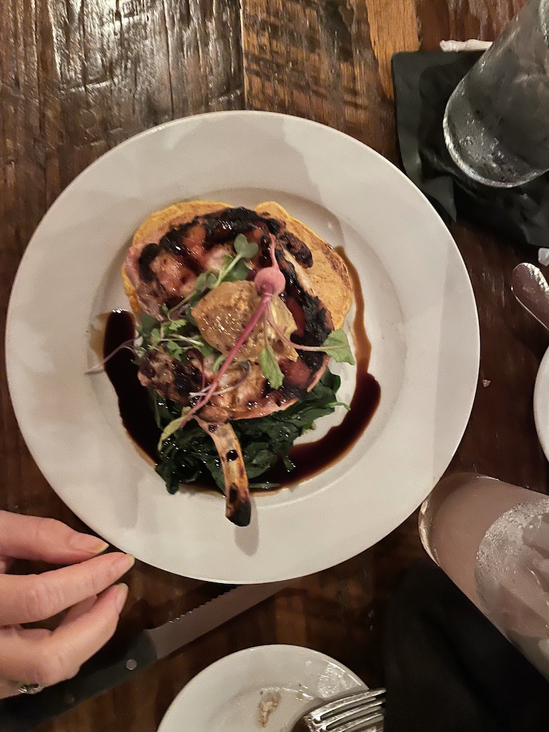 Pork chop served over sweet potato pancakes with molasses butter