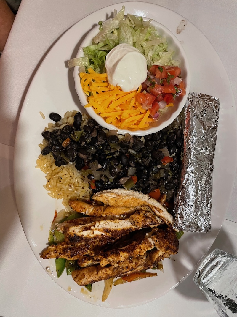 Sizzling chicken fajitas with peppers and onions at Belle Glade Country Club