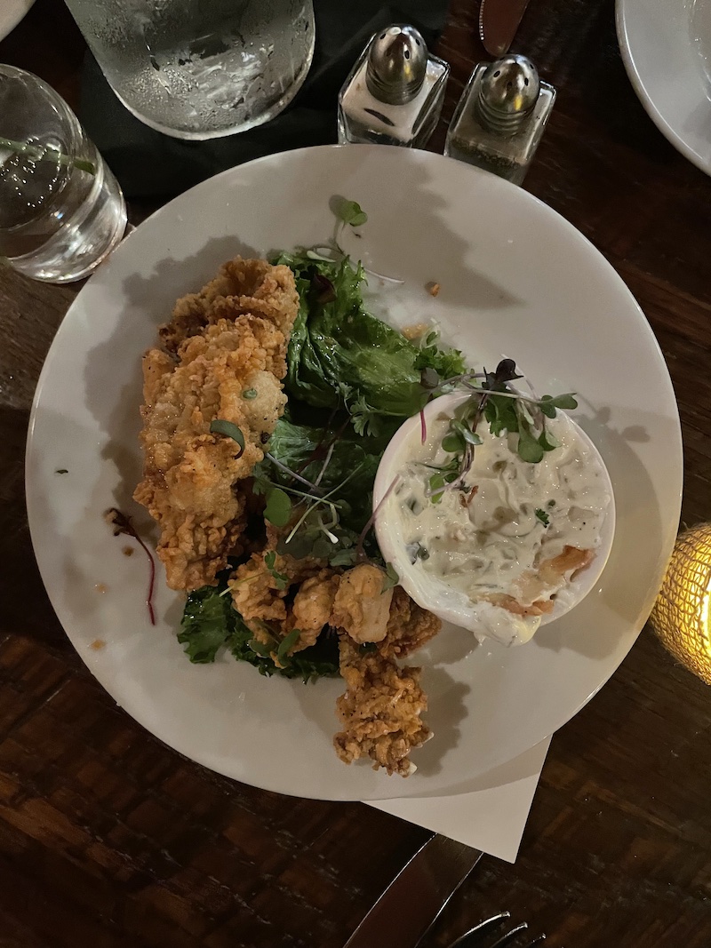 Crispy Gulf Oysters appetizer served with greens and tartar sauce