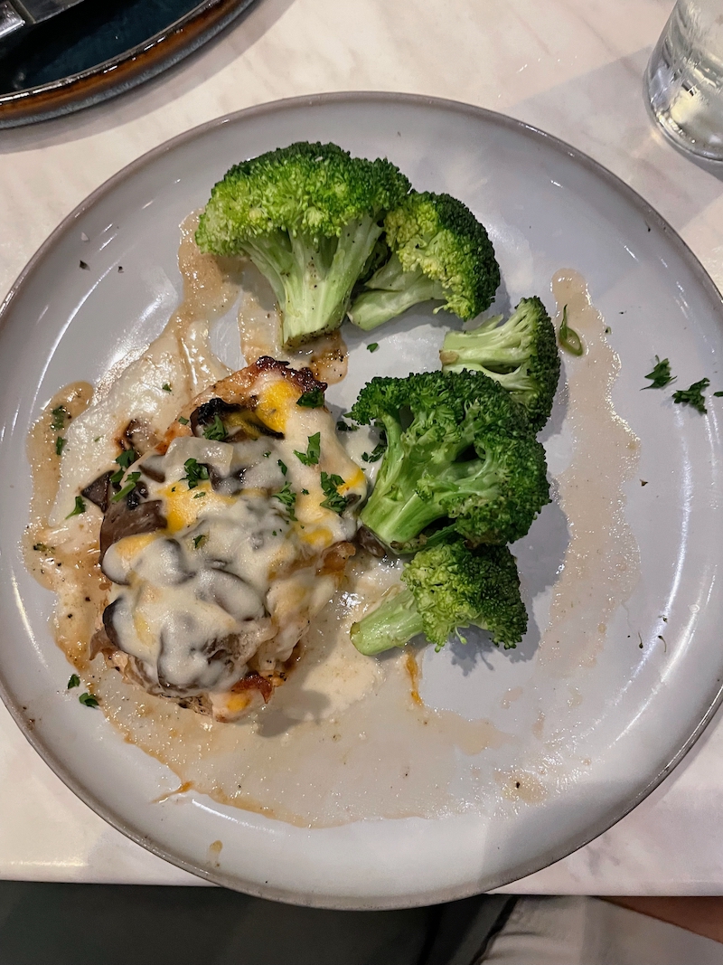 Chicken Gloria with broccoli on dinner plate