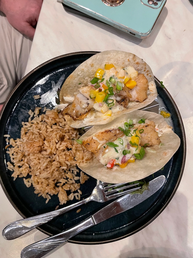 Fish tacos with rice on dark plate