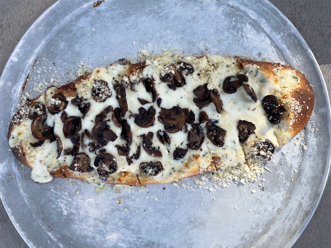 Mushroom flatbread with melted cheese on a thin crust