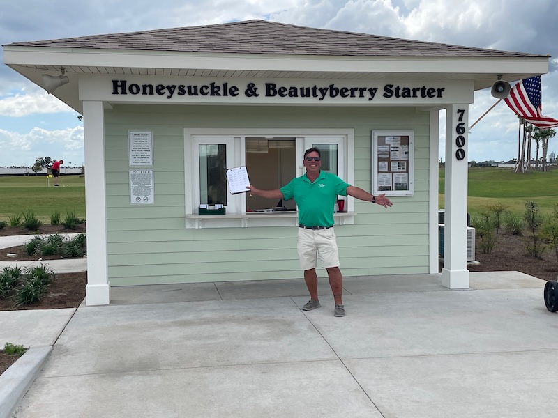 Starter at Honeysuckle and Beautyberry golf course posing in front of starter shack