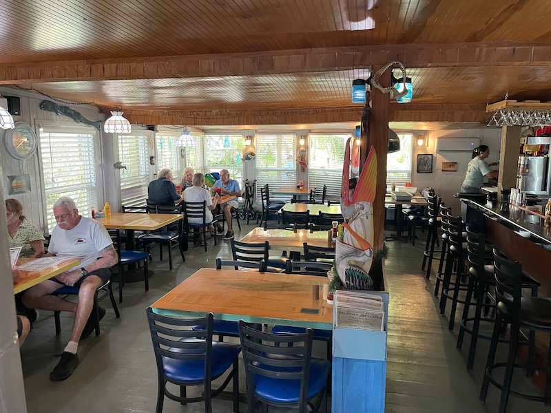 Interior dining room at Fisherman’s Cove with wood ceiling and casual seating