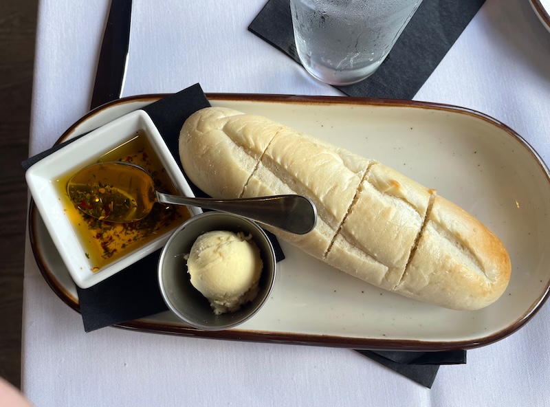 Warm dinner rolls with olive oil seasoning and butter