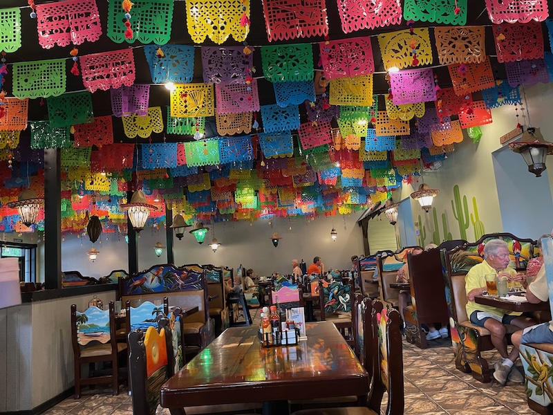 Colorful dining room with papel picado banners and decorated booths