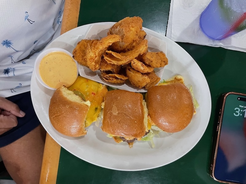 Trio of mini burgers with melted cheese and crispy onion rings