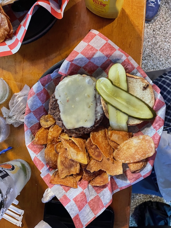 Cheeseburger with melted cheese, pickles, and house chips