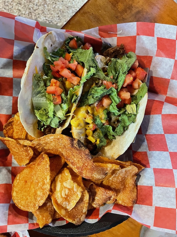 Mahi fish tacos with lettuce, tomato, cheese, and house chips