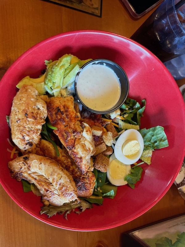 Large salad topped with chicken, avocado, and egg at R.J. Gator’s Lake Sumter Landing